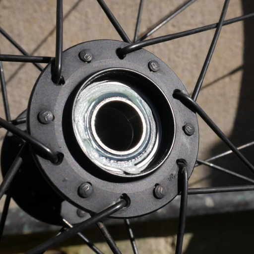How do symptoms differ between front and rear wheel bearings
