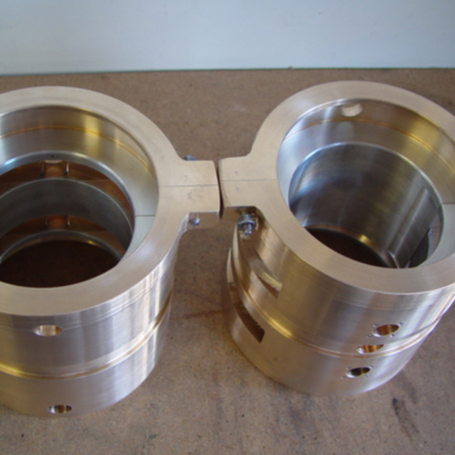 What are the cost considerations when choosing between Babbitt and journal bearings